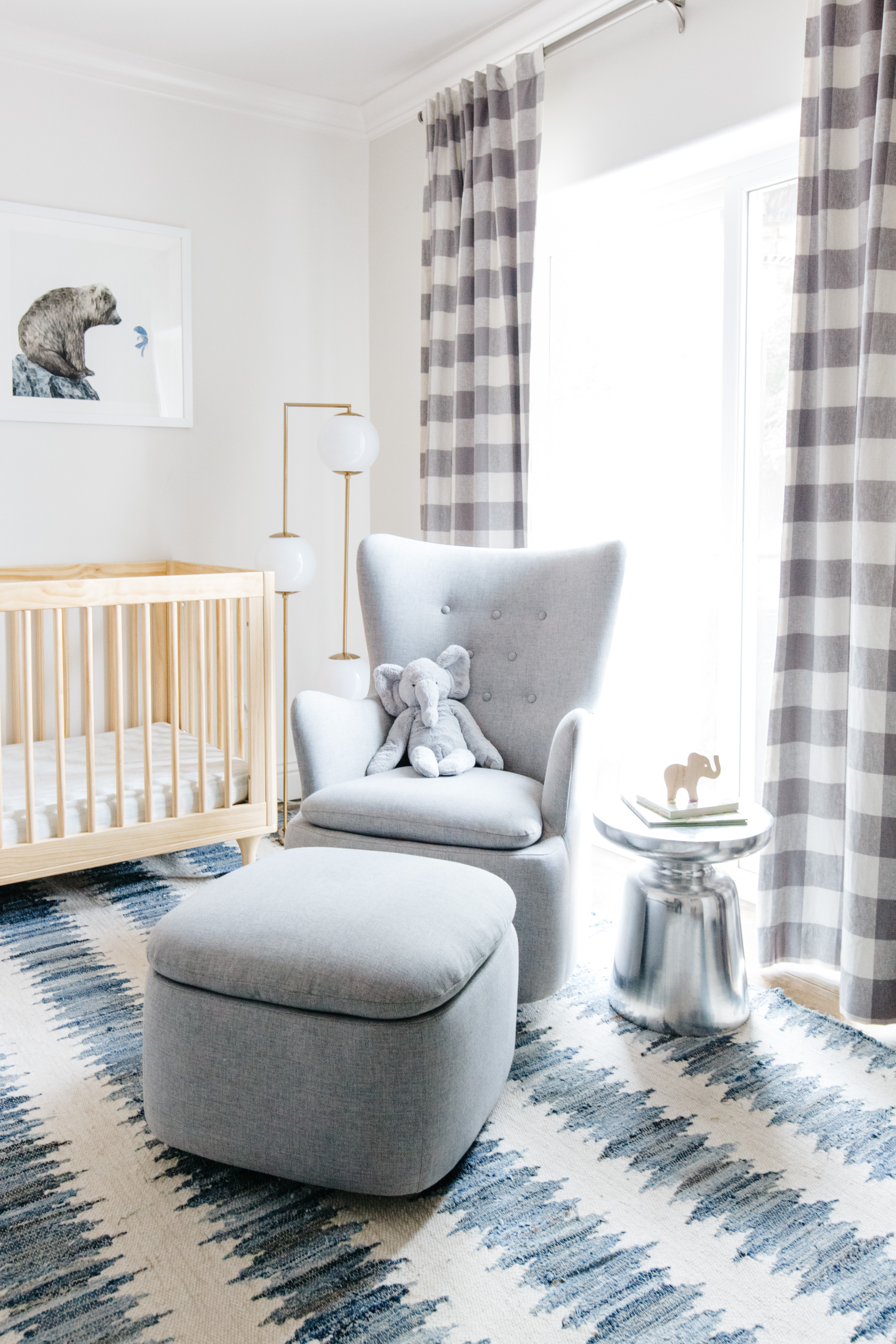 baby nursery with modern blue and white stripped rug gray gingham curtains gray furniture